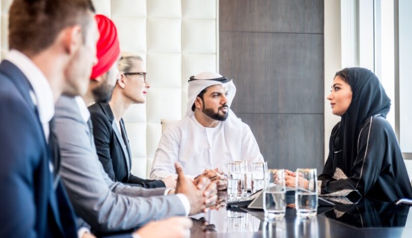 business people sitting at a table in Middle East